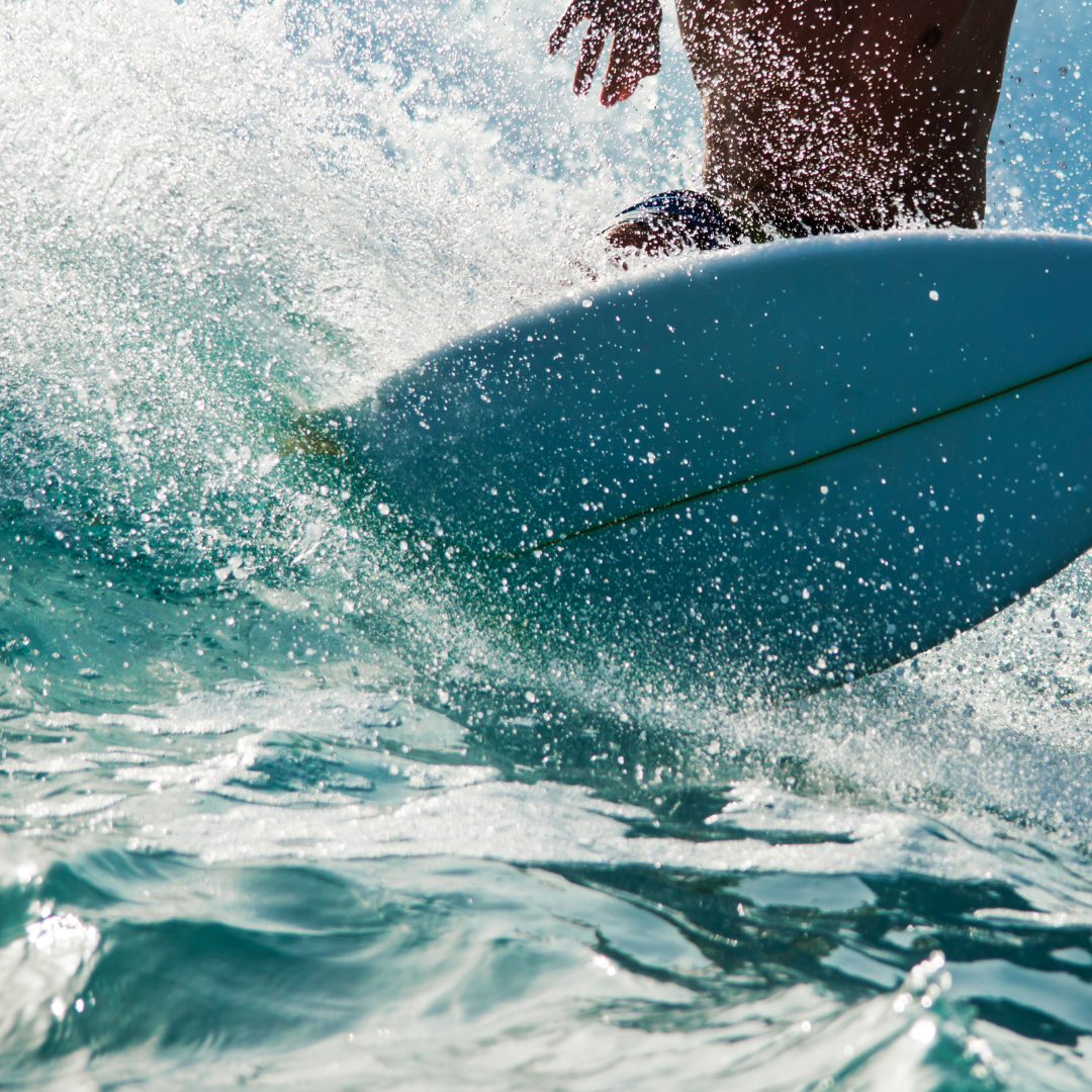 surfing-cabo-san-lucas A close-up of a surfer riding a wave, a popular outdoor wellness activity during a Cabo fitness retreat.