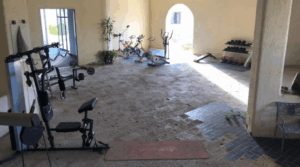 Open-air fitness center at the Cabo San Lucas beachfront resort, with weight machines and cardio equipment.