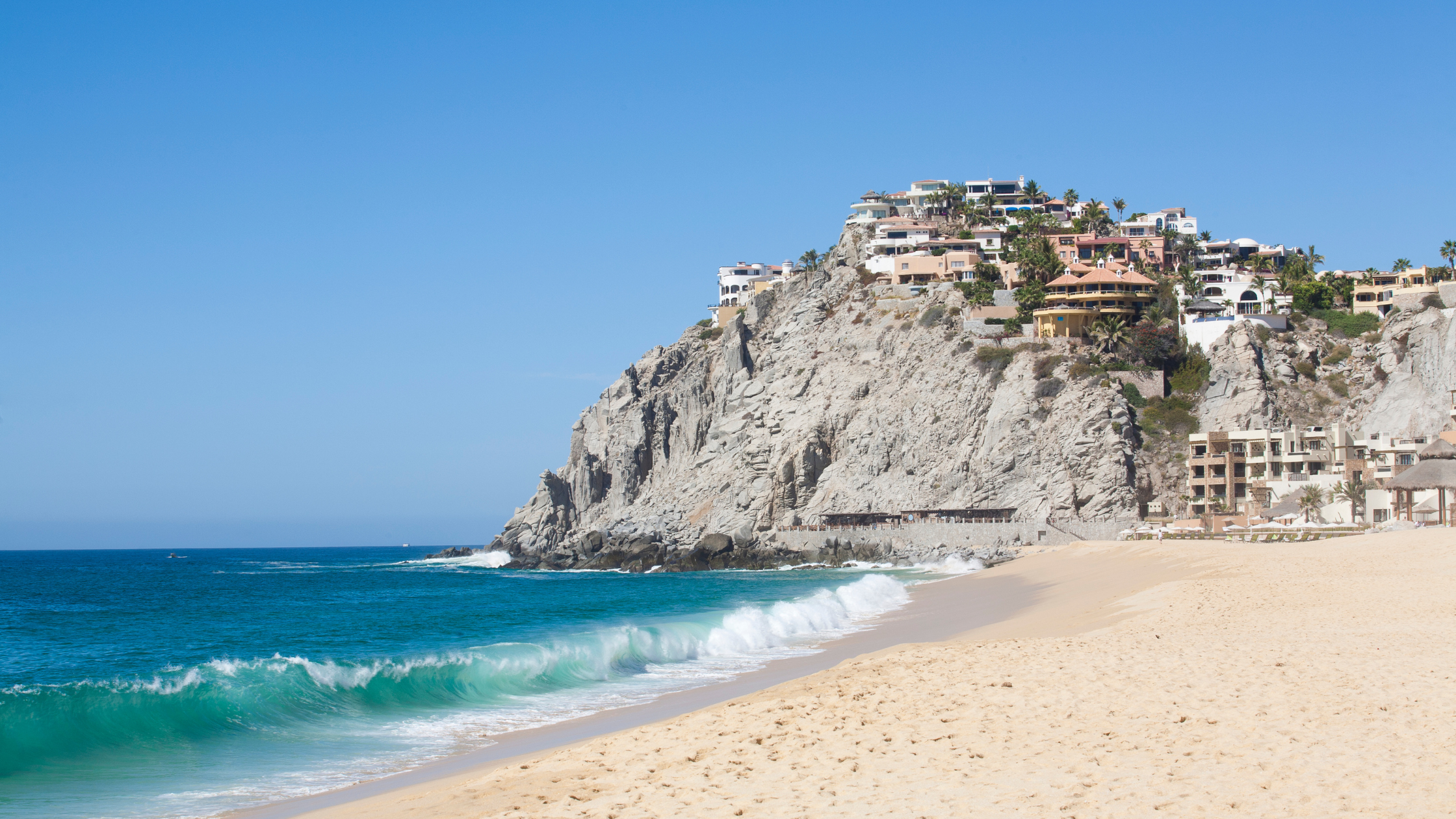 Quiet beach in Cabo San Lucas with rock formations and ocean views, highlighting a peaceful coastal spot close to local attractions.