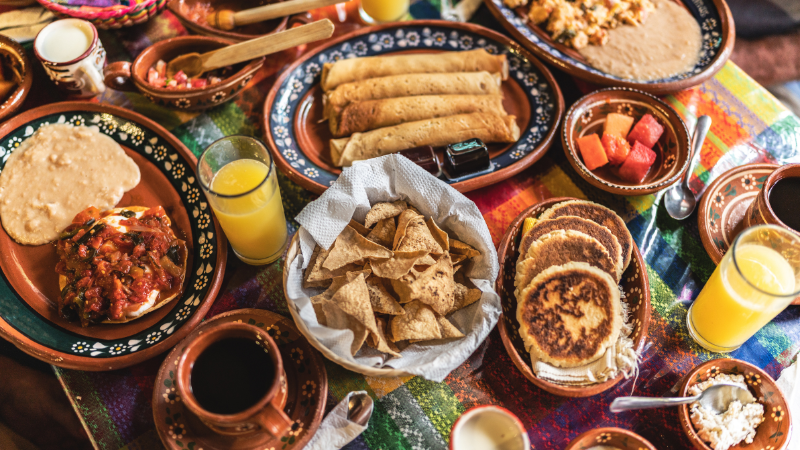 Comida tradicional mexicana con enchiladas, tortillas y zumos naturales. Un ejemplo vibrante de los restaurantes locales de Cabo San Lucas y de las auténticas experiencias gastronómicas.